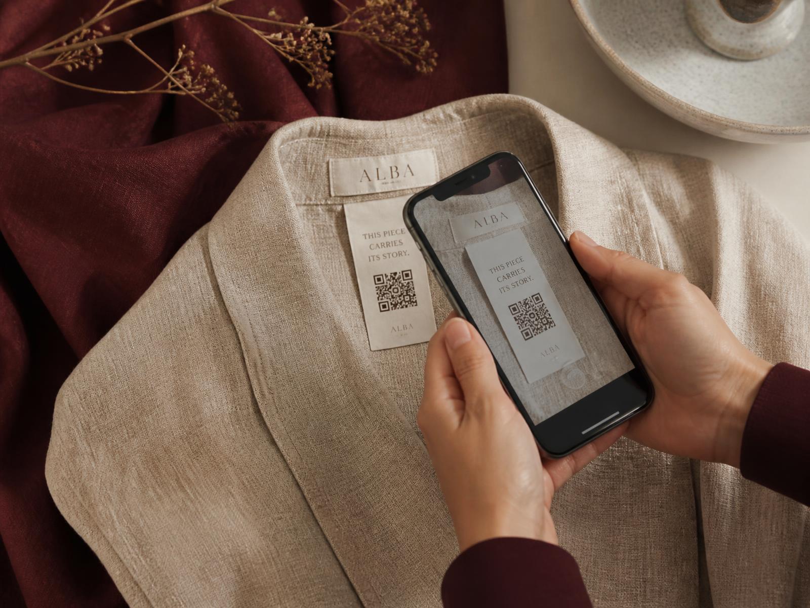 Manos escaneando con un teléfono el código QR de la etiqueta de una prenda de lino
